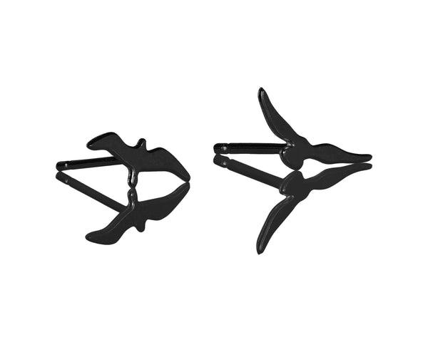 Various black flying bird earrings attached to the ear
