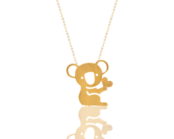 Koala necklace holds a gold heart