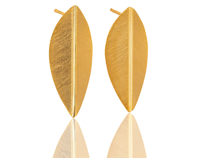 Folded gold leaf earrings close to the ear