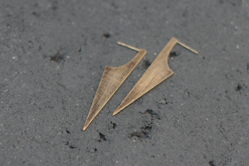 Long attached triangular earrings with texture