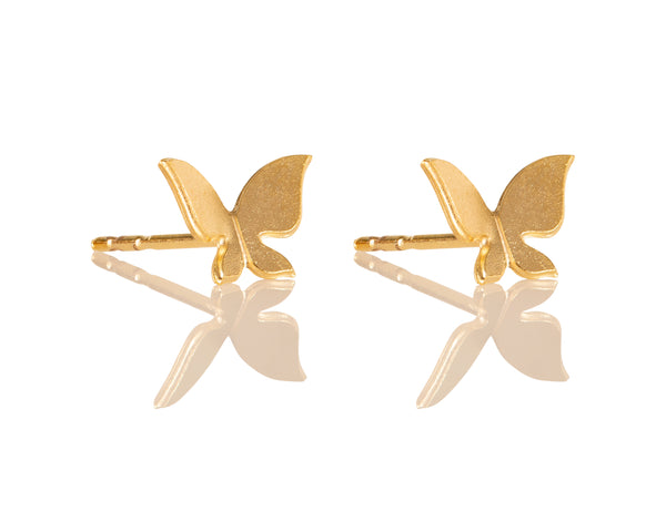 Small flying gold butterfly earrings close to the ear