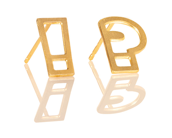 Gold punctuation earrings attached to the ear, an exclamation mark and a question mark