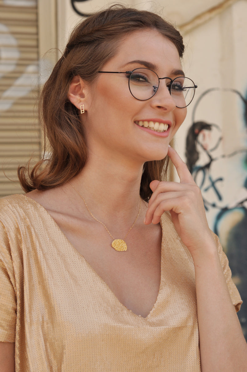 Gold punctuation earrings attached to the ear, an exclamation mark and a question mark