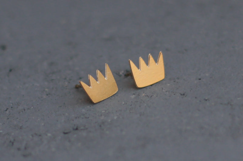 Gold crown earrings close to the ear