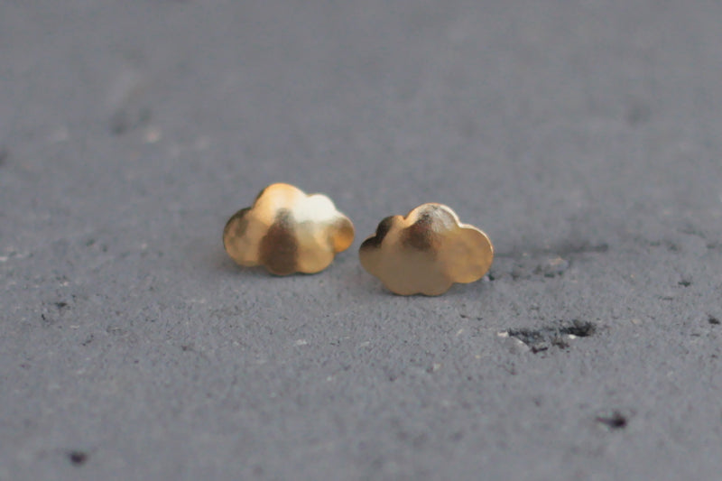 Gold cloud earrings close to the ear