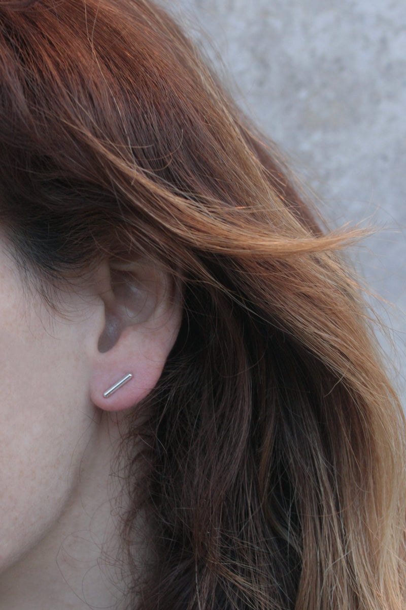 Silver stud earrings attached to the ear