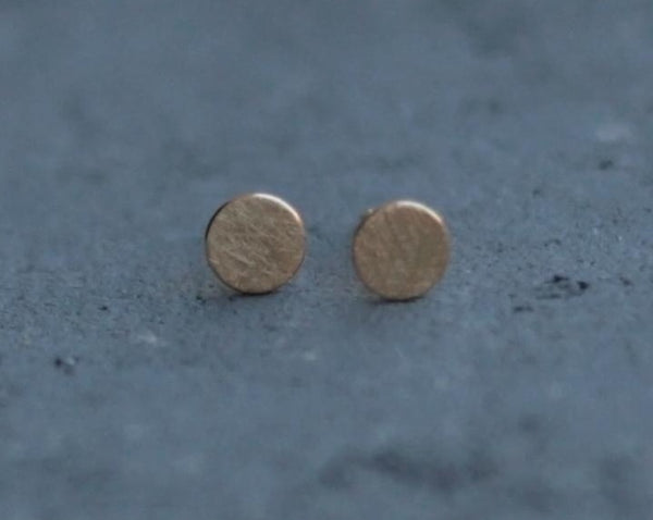 Small circle earrings attached to a gold ear
