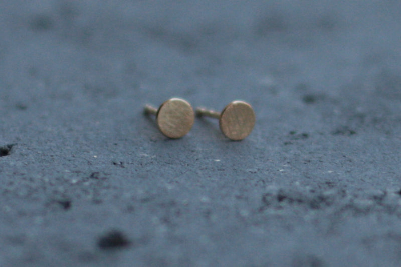 Small circle earrings attached to a gold ear
