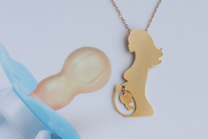 Golden necklace of a pregnant woman with a fetus swinging in her belly