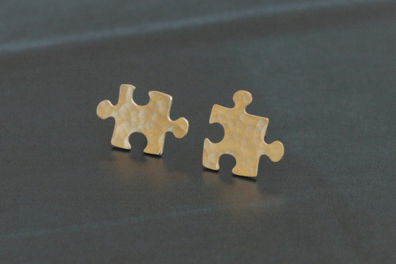 Golden puzzle earrings attached to the ear