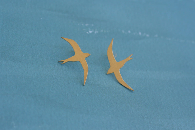Gold flying bird earrings attached