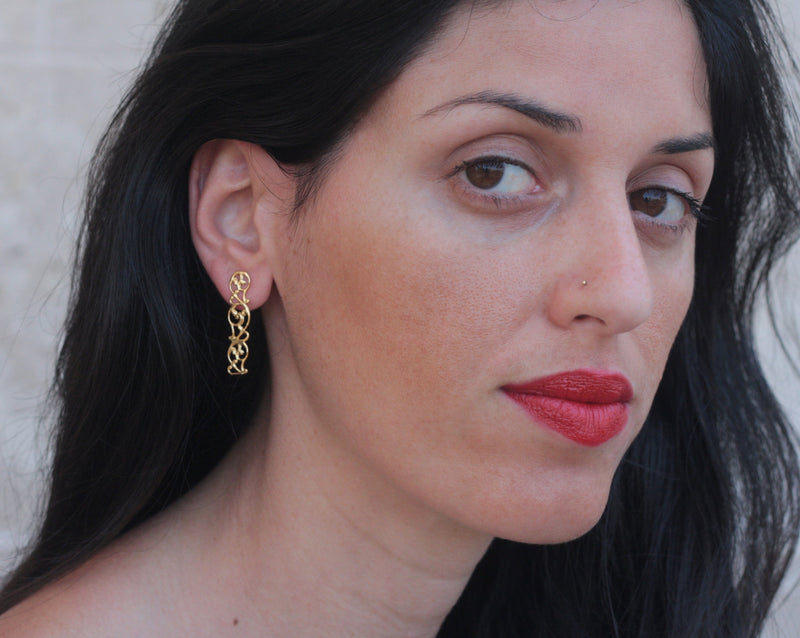 Golden and delicate lace band earrings close to the ear