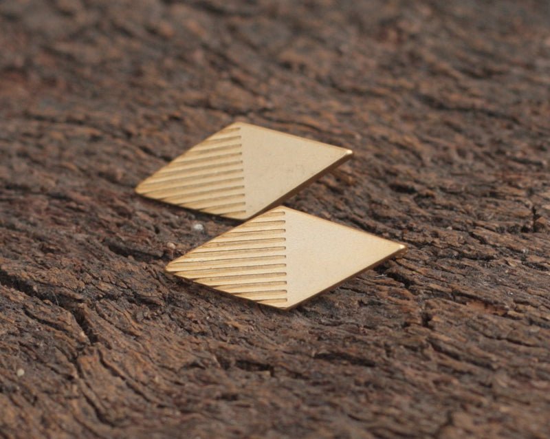 Gold rhombus earrings with stripes close to the ear