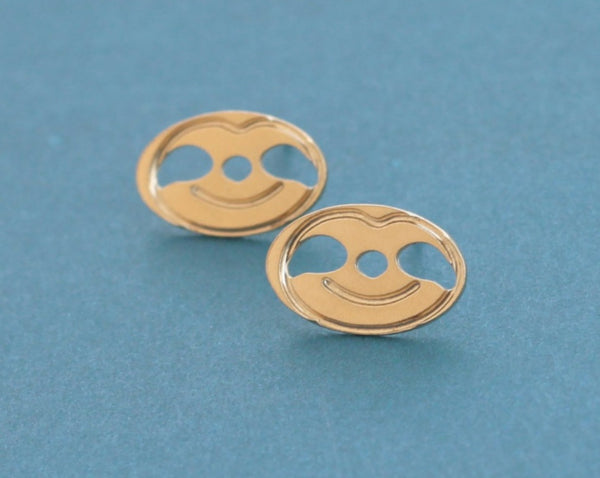 Earrings of a smiling sloth close to the ear