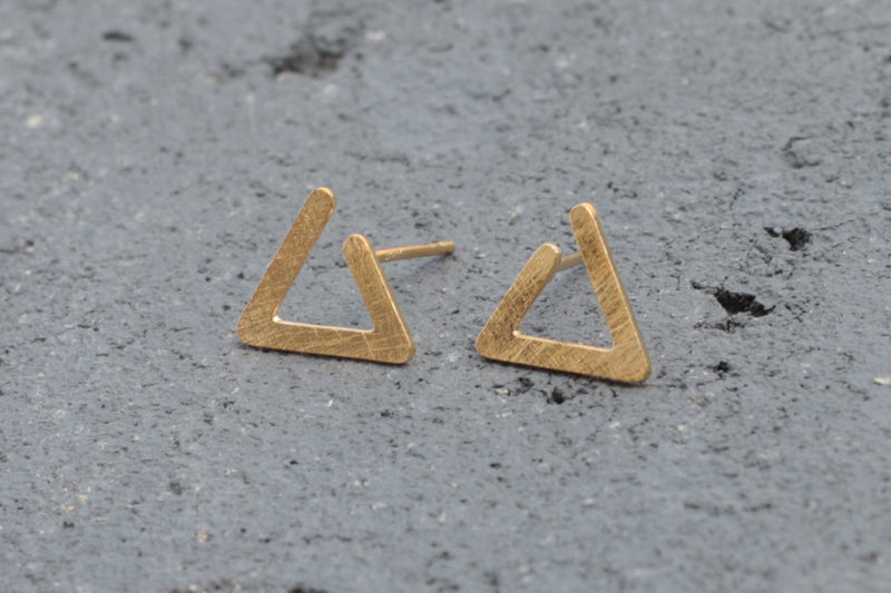 Geometric open triangle earrings attached to the ear