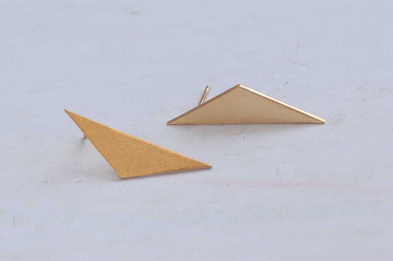 Gold triangle earrings attached to the ear