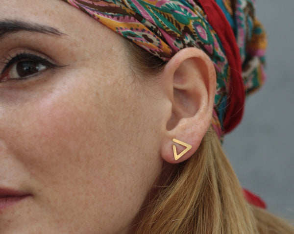 Geometric open triangle earrings attached to the ear