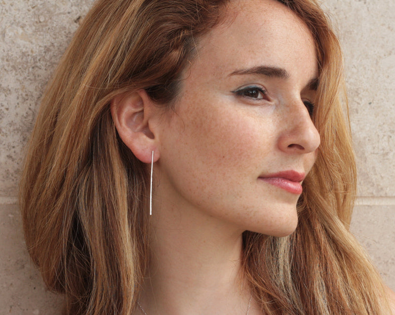 Hammered silver band earrings close to the ear