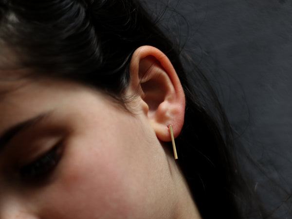 Long rectangular bar earrings close to the ear