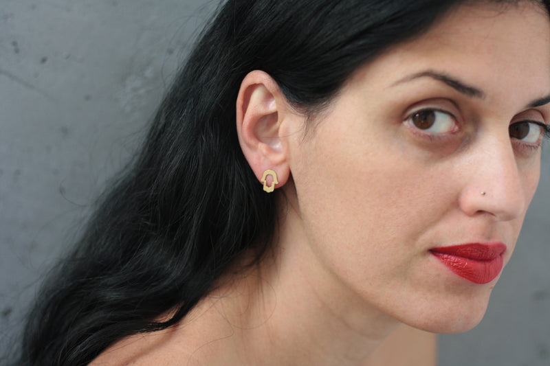 Hamsa gold earrings attached to the ear