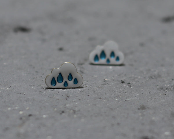 White cloud earrings with blue raindrops, close to the ear