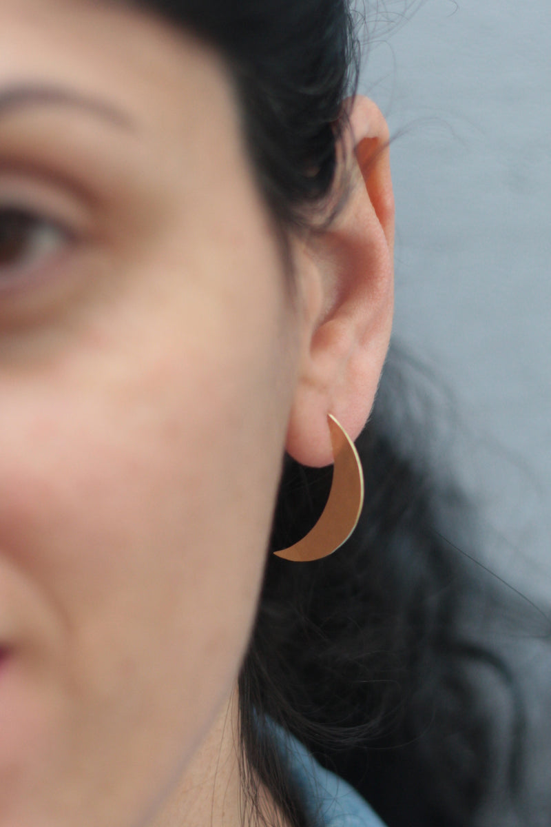 Half moon earrings attached to the ear