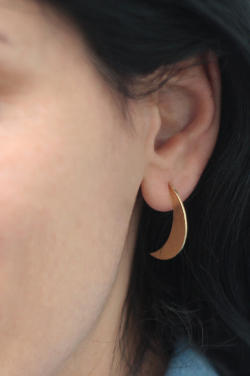 Half moon earrings attached to the ear