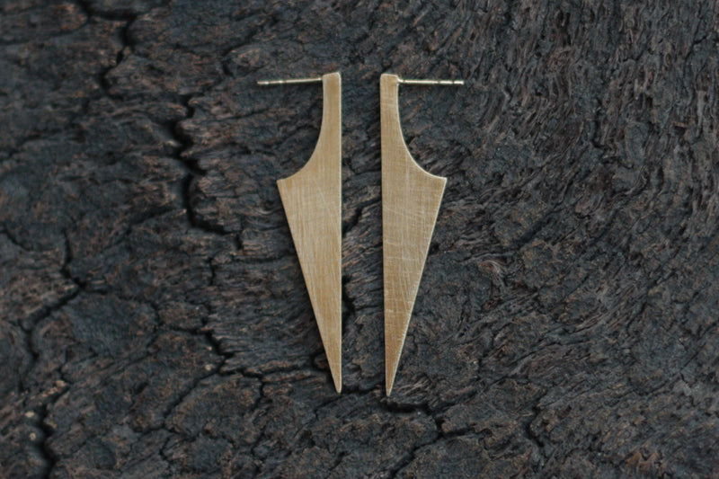 Long attached triangular earrings with texture