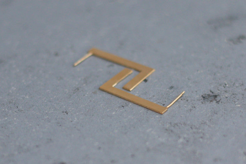 Open and minimalist flat rectangle earrings close to the ear