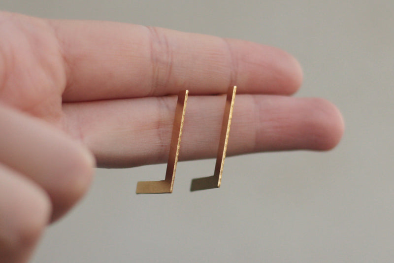 Open and minimalist flat rectangle earrings close to the ear