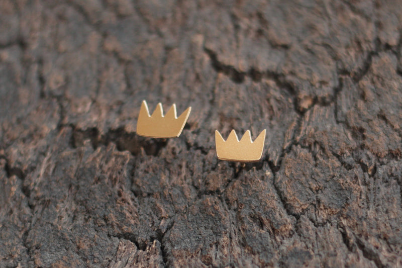 Gold crown earrings close to the ear