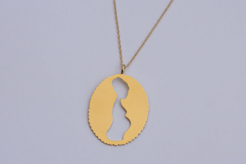 Goldfield necklace with an oval pendant of a pregnant woman